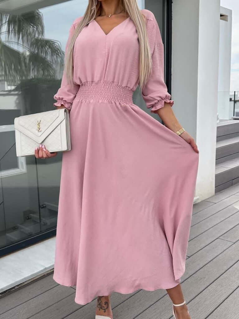 Robe longue rose avec manches bouffantes, ceinture smockée, tenue élégante pour occasions spéciales.